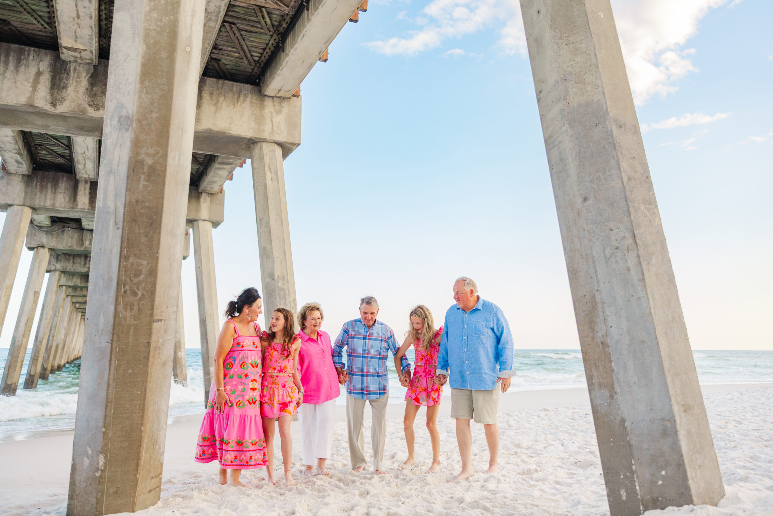 family wearing pinks and blues by the pensacola beach fishing pier