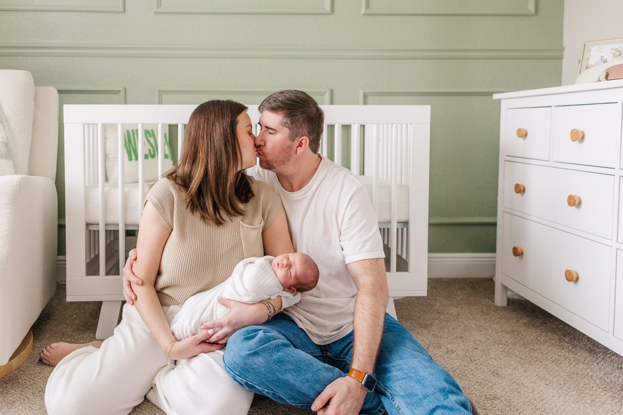 mom dad and baby in the nursery